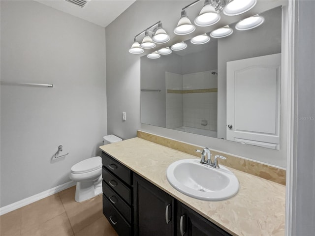 bathroom featuring tile patterned floors, toilet, vanity, and a shower