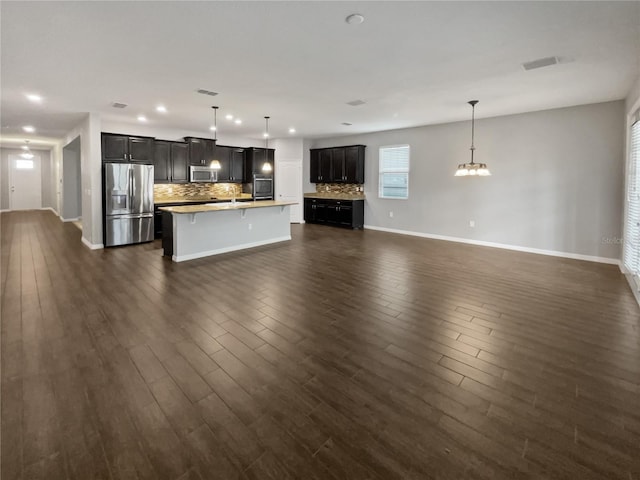 unfurnished living room featuring dark hardwood / wood-style flooring and a notable chandelier