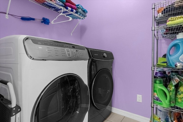 clothes washing area with washing machine and clothes dryer and light tile patterned floors