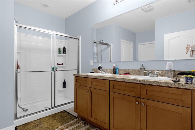 bathroom with tile patterned floors, walk in shower, and dual bowl vanity