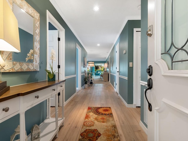 hallway with light wood-style floors, baseboards, ornamental molding, and recessed lighting