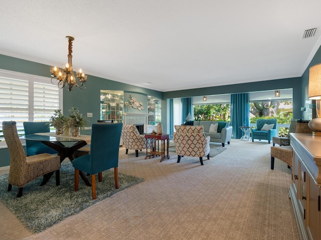 carpeted dining area with a chandelier, ornamental molding, a tile fireplace, and visible vents