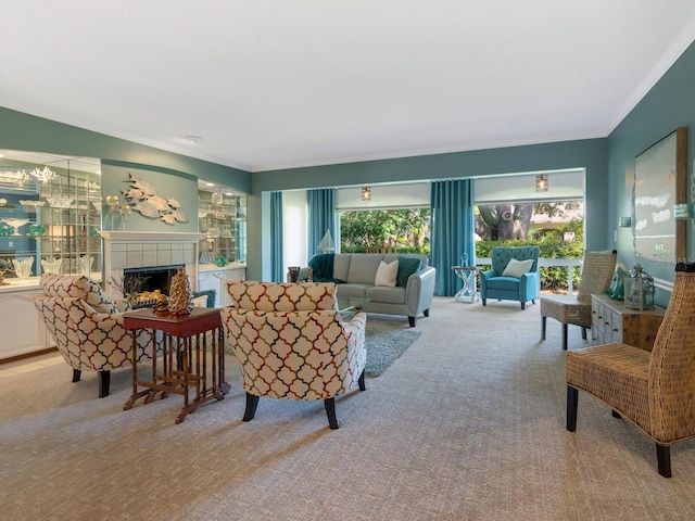 living room featuring carpet floors, ornamental molding, and a tiled fireplace