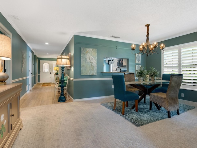 carpeted dining space featuring ornamental molding and an inviting chandelier