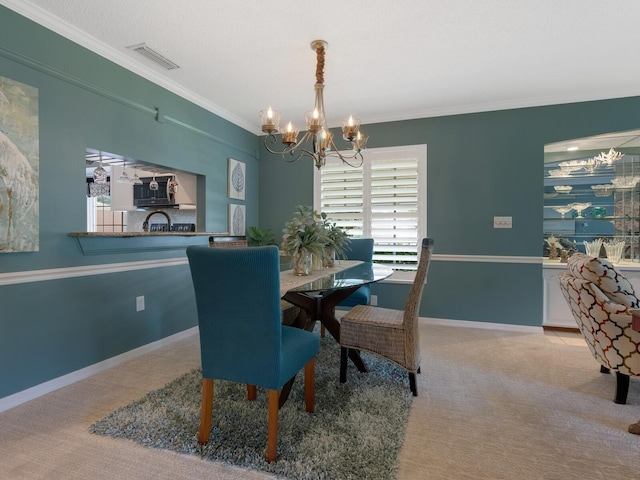 carpeted dining room featuring baseboards, crown molding, visible vents, and a notable chandelier