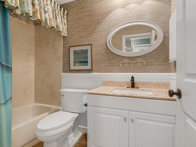 bathroom with a wainscoted wall, vanity, toilet, and shower / bathtub combination with curtain