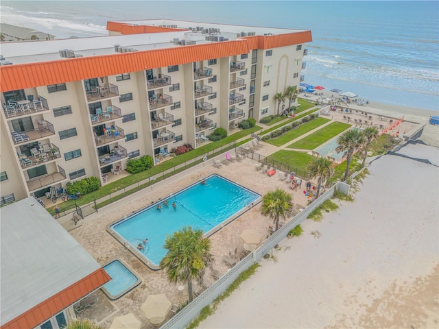 view of pool featuring a water view and a beach view