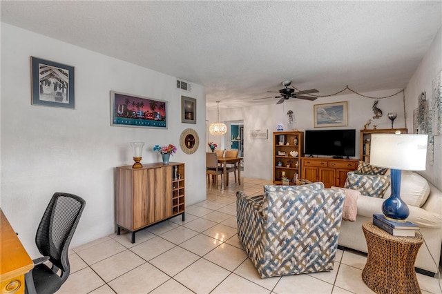 tiled living room featuring a textured ceiling and ceiling fan