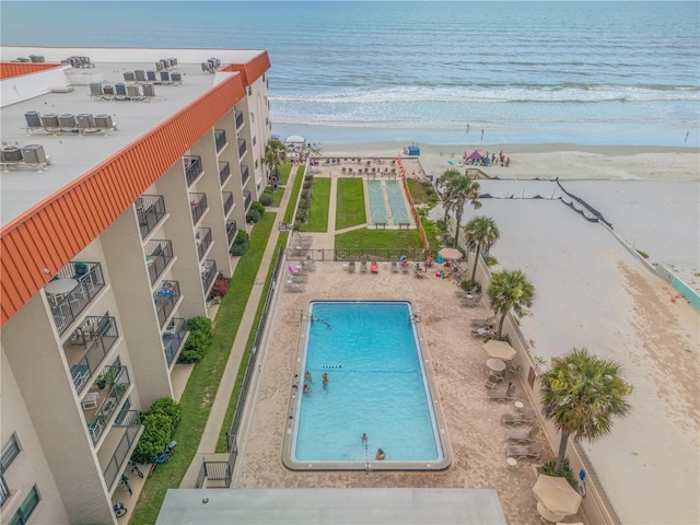 view of swimming pool featuring a water view and a beach view