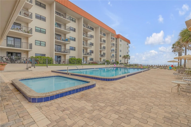 view of pool featuring a community hot tub and a patio area