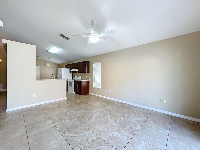 interior space featuring dark brown cabinetry, lofted ceiling, stainless steel range with electric stovetop, refrigerator, and ceiling fan