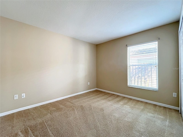 carpeted spare room featuring a textured ceiling