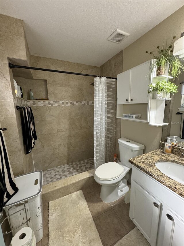 bathroom featuring toilet, vanity, a shower with curtain, and a textured ceiling