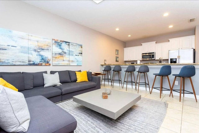 tiled living room featuring sink