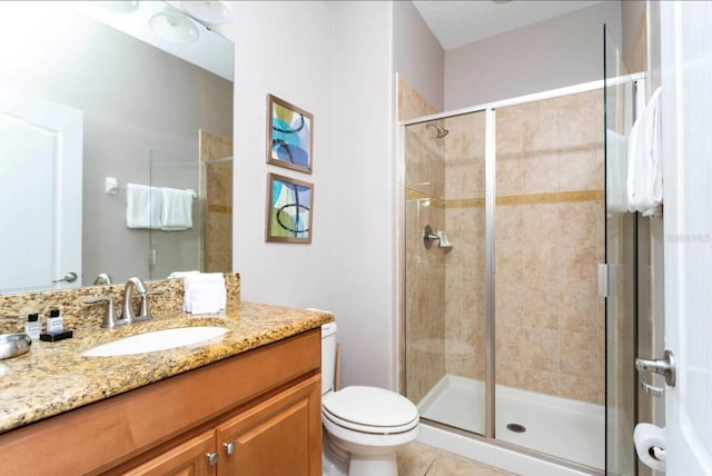 bathroom featuring vanity, toilet, an enclosed shower, and tile patterned floors