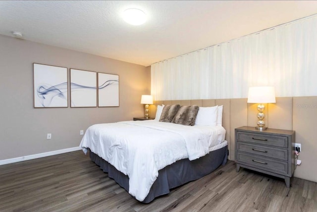 bedroom featuring a textured ceiling and dark hardwood / wood-style floors