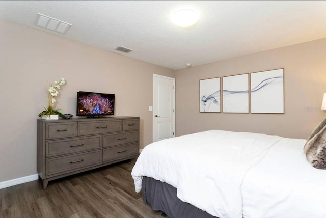 bedroom featuring a textured ceiling and dark hardwood / wood-style floors