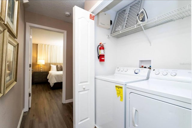 laundry room with a textured ceiling, separate washer and dryer, and dark hardwood / wood-style floors