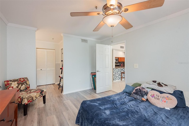 bedroom with ceiling fan, a closet, light wood-type flooring, and ornamental molding