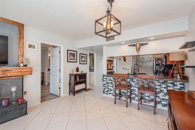 kitchen with light tile patterned flooring, sink, a chandelier, and decorative light fixtures