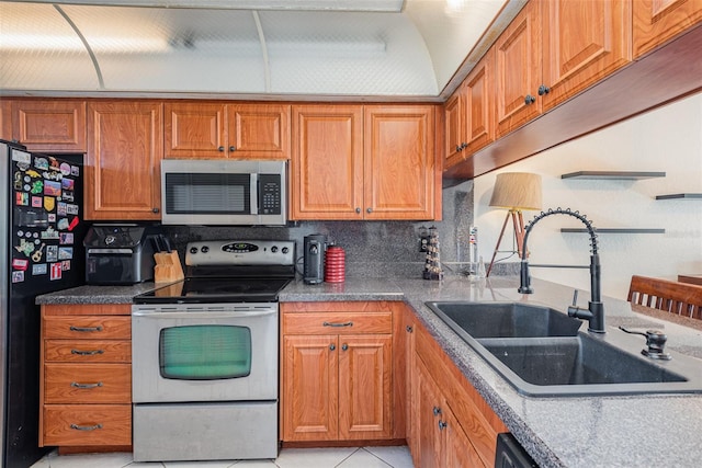 kitchen featuring light tile patterned floors, appliances with stainless steel finishes, tasteful backsplash, and sink