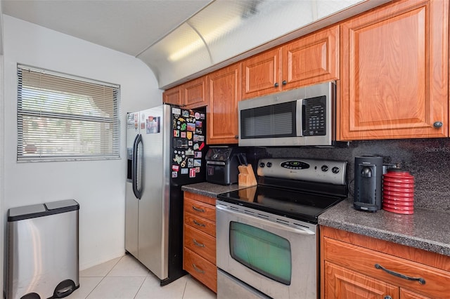 kitchen with light tile patterned floors, backsplash, and appliances with stainless steel finishes