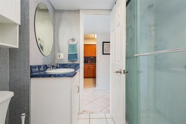 bathroom with a shower with shower door, toilet, vanity, and tile patterned flooring