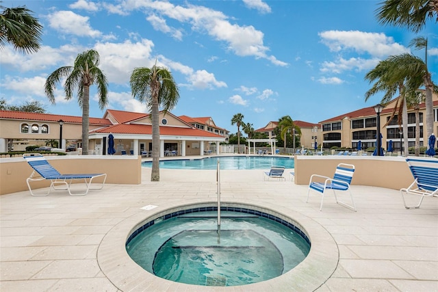 view of swimming pool with a patio area and a community hot tub