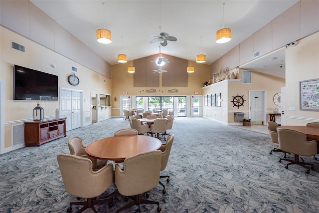 dining room with light carpet and high vaulted ceiling