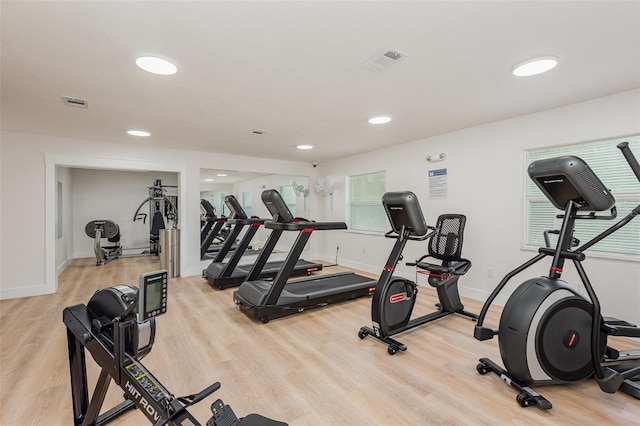 exercise room with light hardwood / wood-style floors