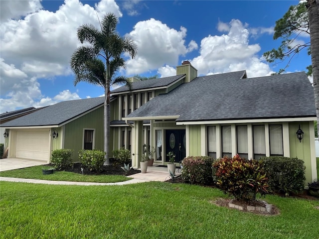 view of front of property featuring a garage and a front lawn