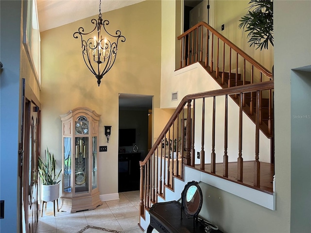 tiled foyer with a chandelier and a high ceiling