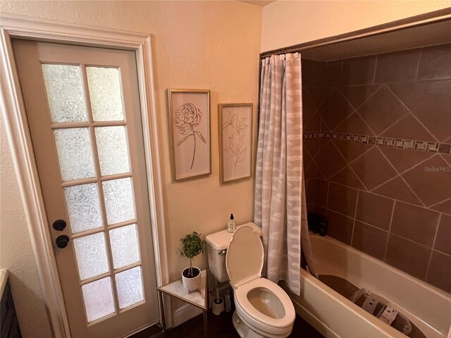 bathroom featuring toilet and shower / bath combo with shower curtain