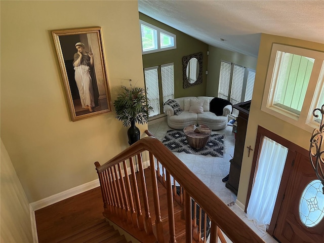 interior space featuring lofted ceiling, hardwood / wood-style flooring, and a textured ceiling