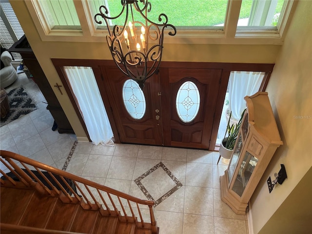 tiled foyer with a towering ceiling and a notable chandelier