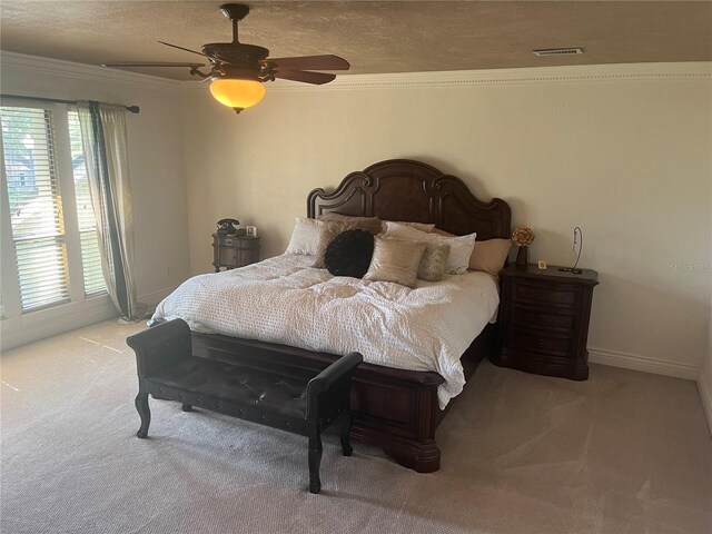 carpeted bedroom with ceiling fan and crown molding