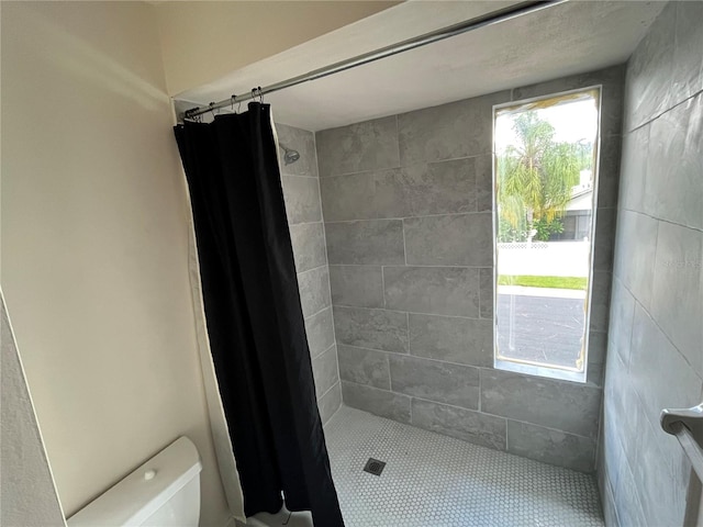 bathroom featuring a shower with curtain and toilet