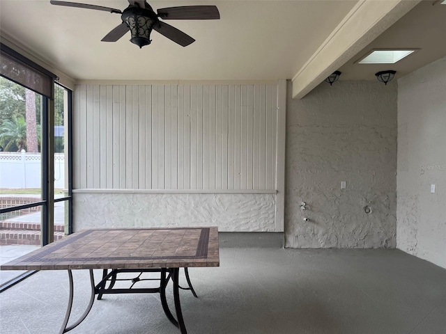 sunroom / solarium featuring ceiling fan and a skylight