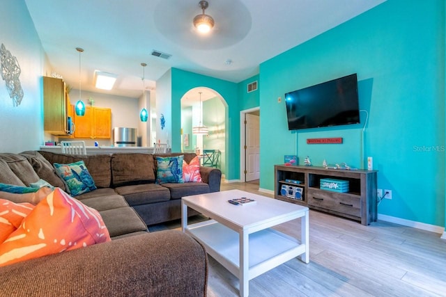 living room with light hardwood / wood-style flooring and ceiling fan