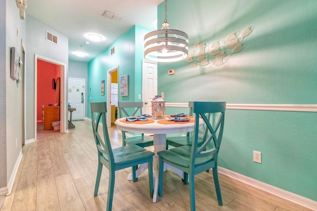 dining area featuring a notable chandelier and light wood-type flooring