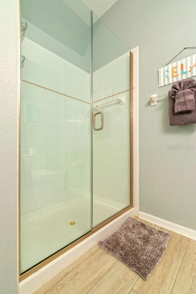 bathroom featuring wood-type flooring and an enclosed shower