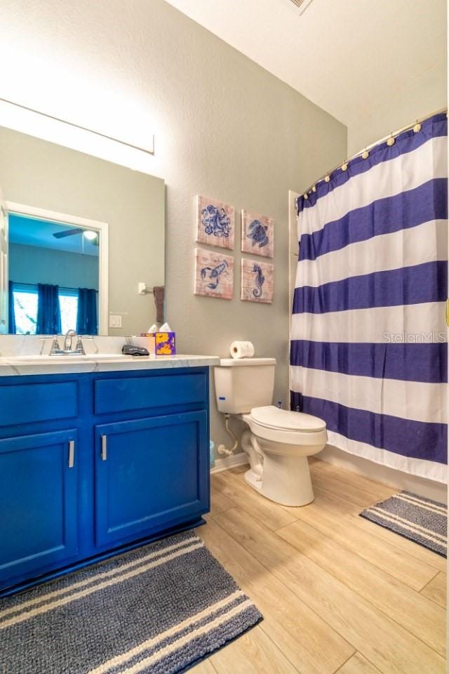 bathroom with hardwood / wood-style floors, vanity, and toilet