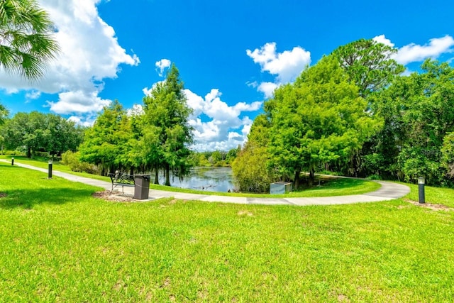 view of property's community with a water view and a yard