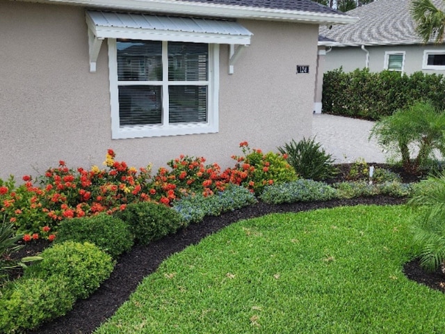 view of side of home with a yard