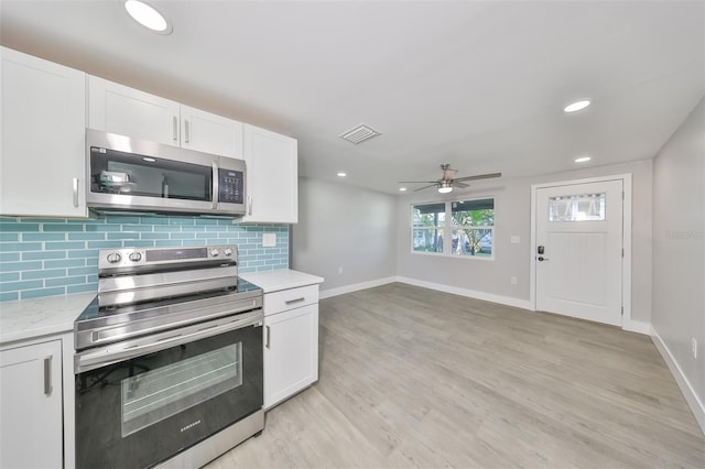 kitchen with ceiling fan, white cabinets, tasteful backsplash, light hardwood / wood-style floors, and stainless steel appliances