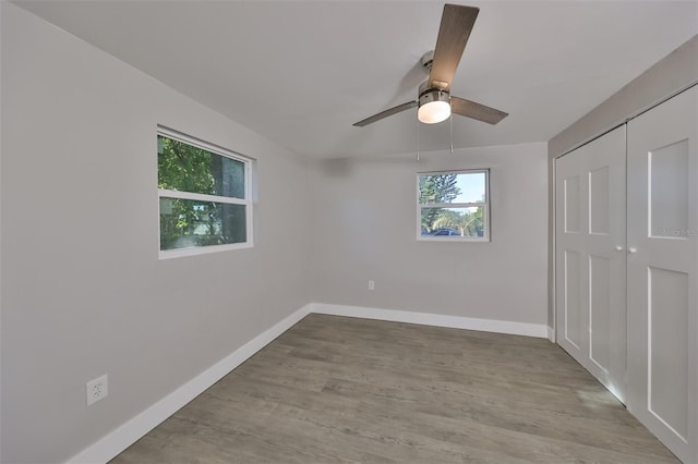 unfurnished bedroom with light hardwood / wood-style flooring, a closet, and ceiling fan