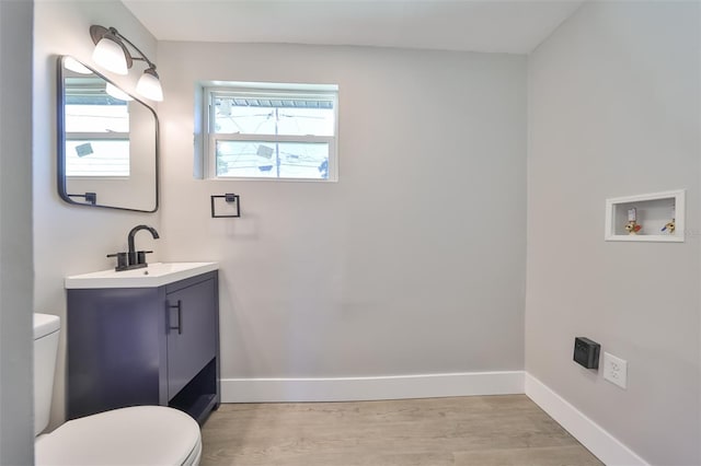 bathroom with hardwood / wood-style floors, toilet, and vanity