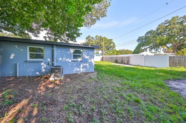 back of property with a yard and central AC unit