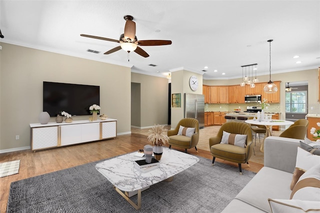 living room featuring ceiling fan, light wood-type flooring, and ornamental molding