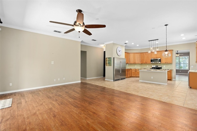 kitchen featuring a kitchen island, decorative light fixtures, stainless steel appliances, light wood-type flooring, and crown molding